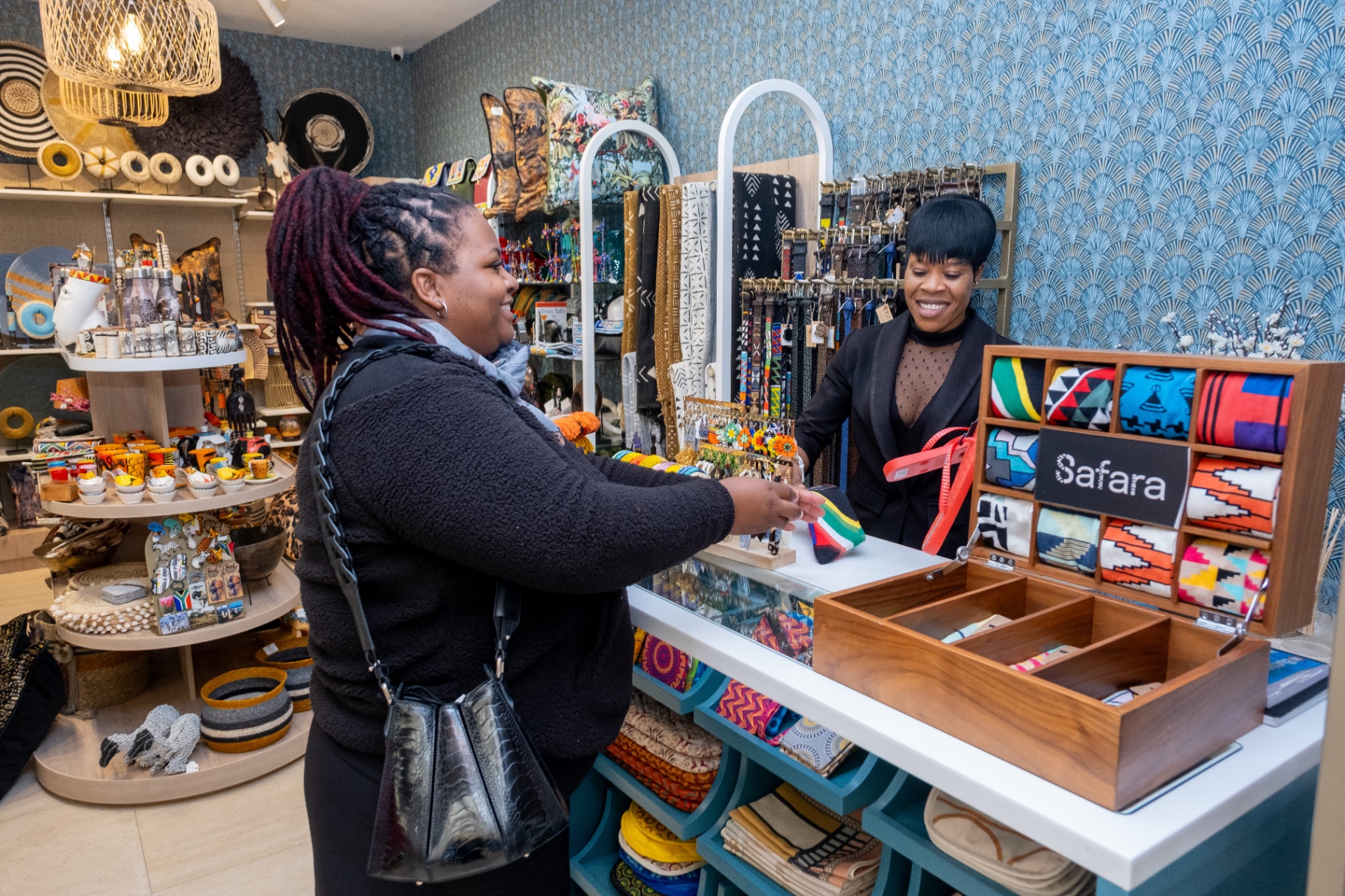 Customer being served at the Safara checkout counter in Camps Bay, Cape Town